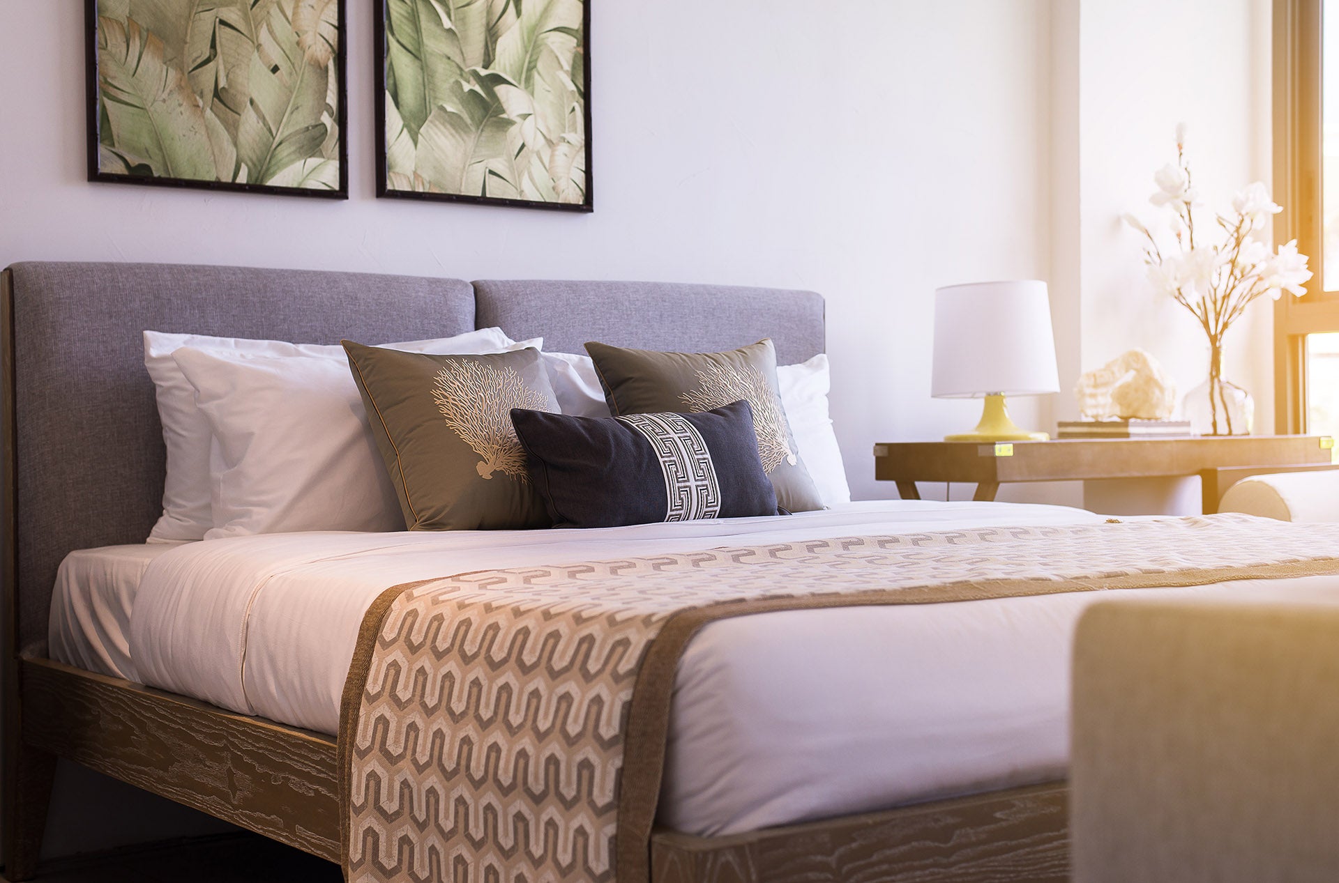 Modern king sized bed with cusions, bedside table and lamp
