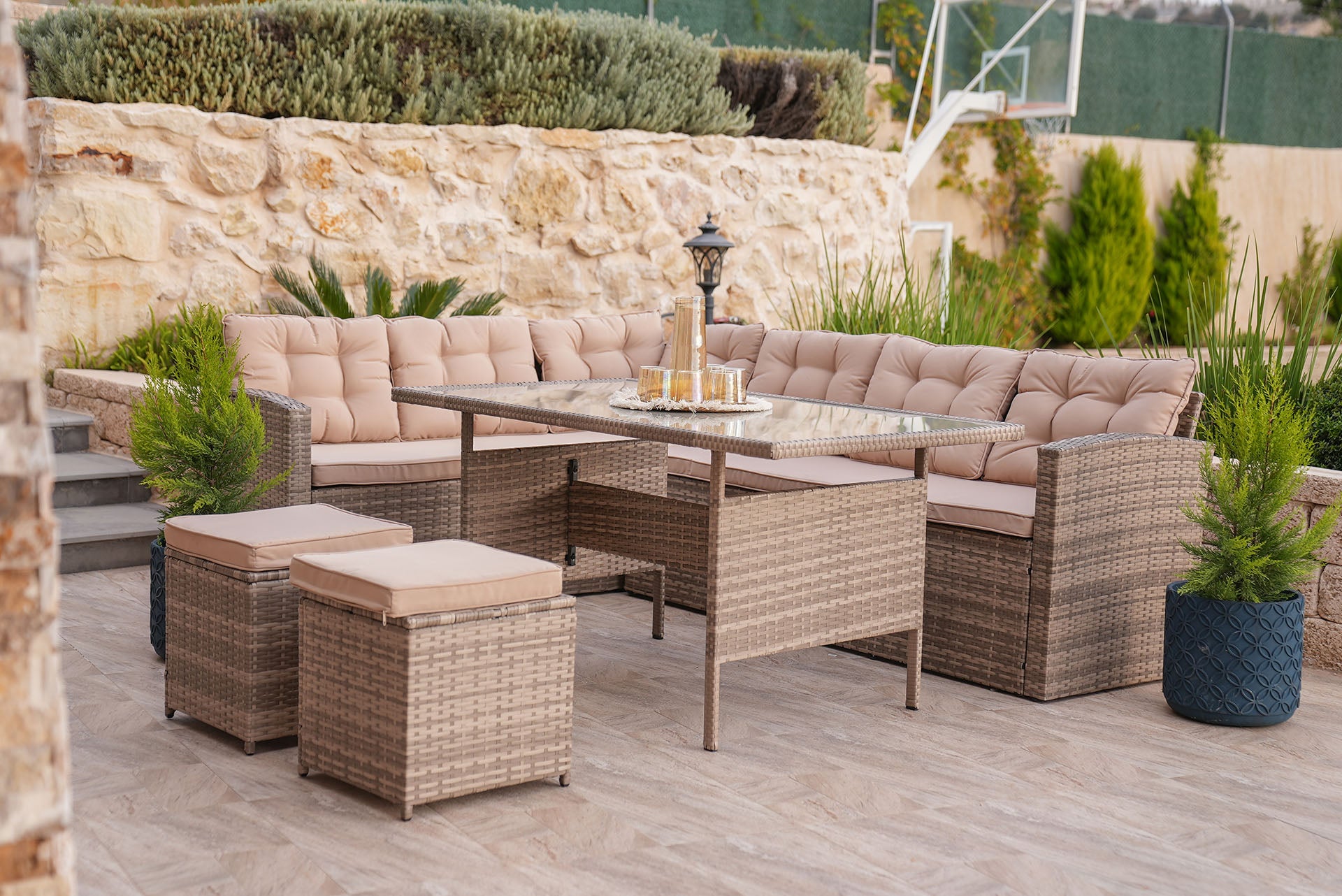Modern garden furniture set with l shaped sofa and cushions and glass table